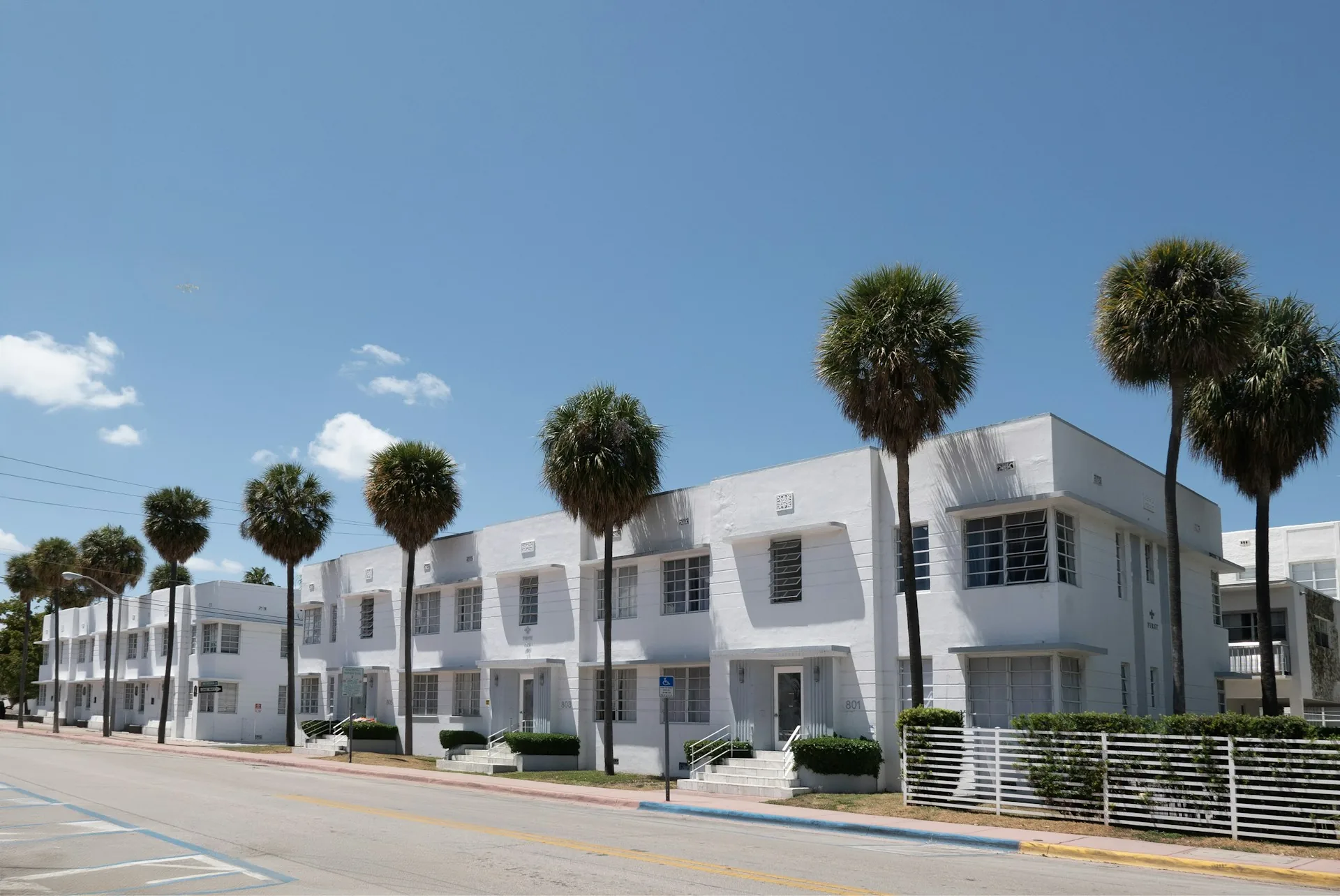 White low-rise apartment buildings with palm trees